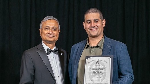 CMRP PhD student Luis Munoz holding AAPM award, with Saiful Huq, the previous year’s AAPM president.